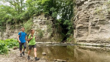 Zwei Wanderer gehen am Felsentor Prümer Tor an der Ahr vorbei